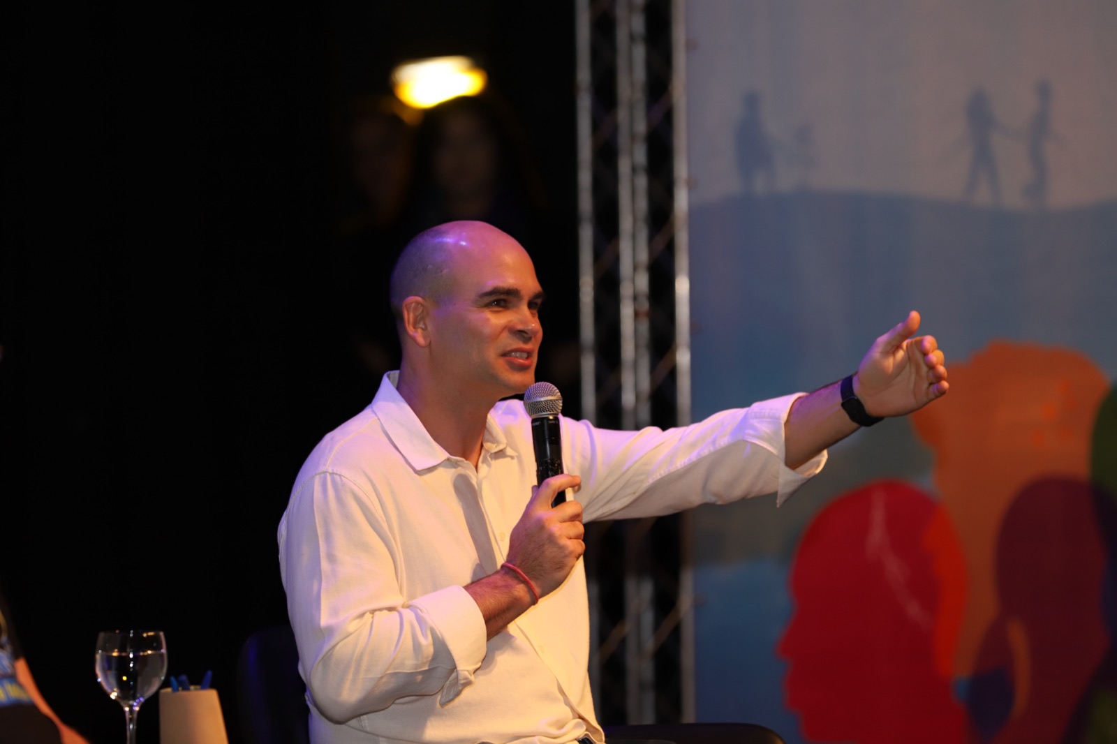 Felipe Lapa fala ao microfone num palco