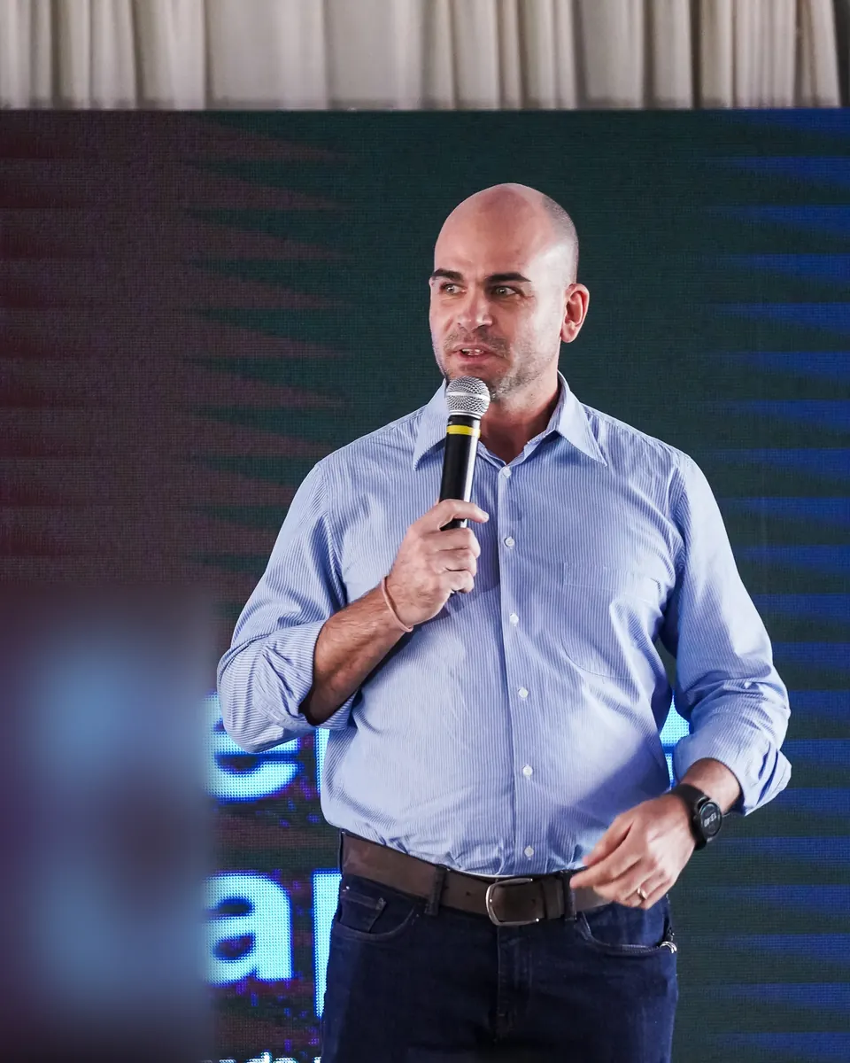 Felipe Lapa no palco, ao microfone, sozinho no enquadramento