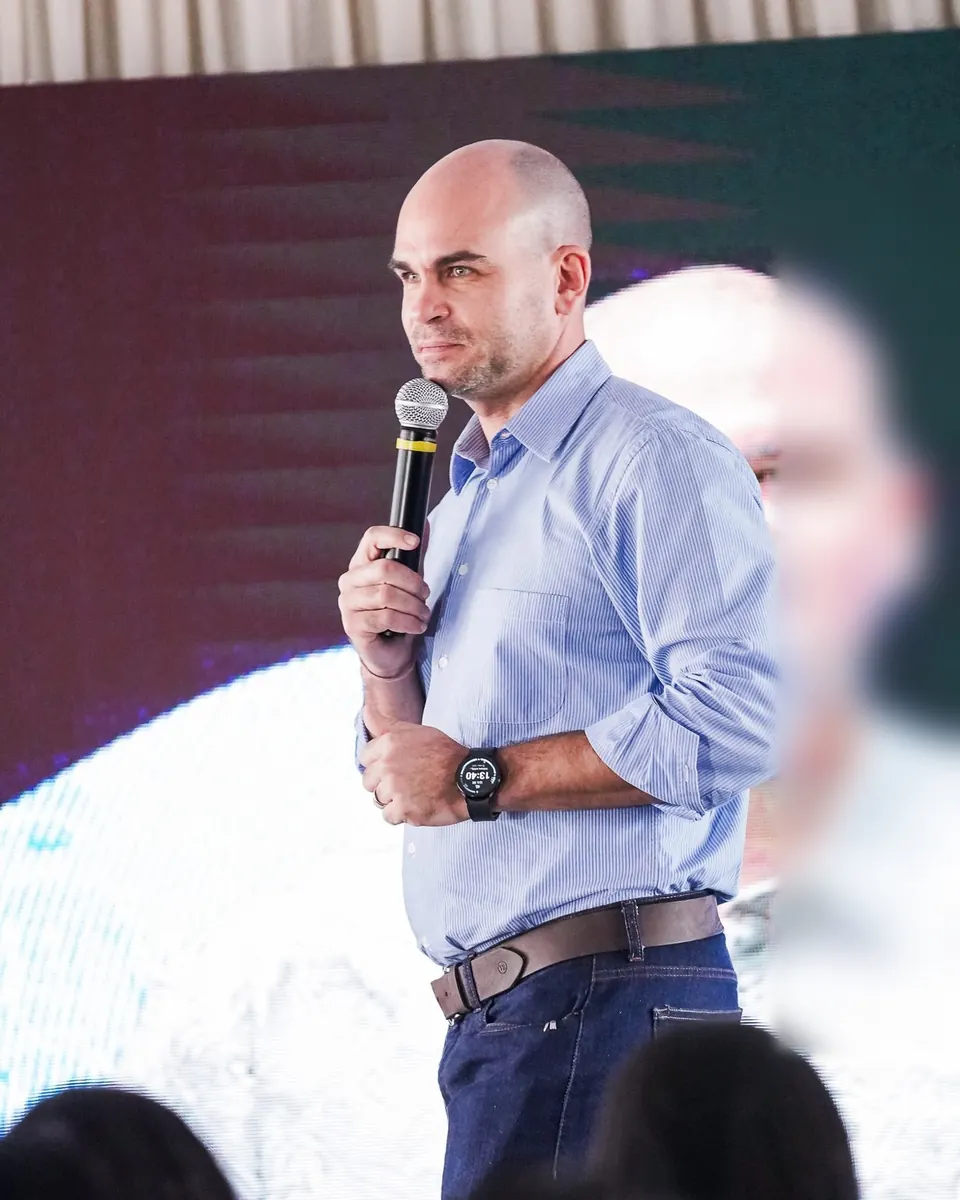 Felipe Lapa no palco, ao microfone, olhando a plateia