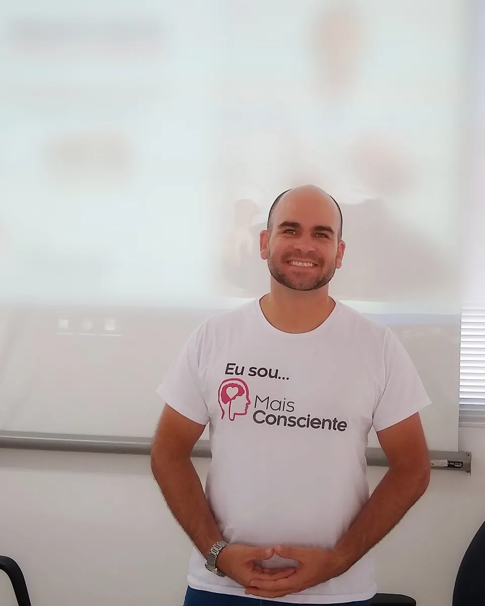 Felipe Lapa de camiseta branca, sorrindo, numa sala de treinamento