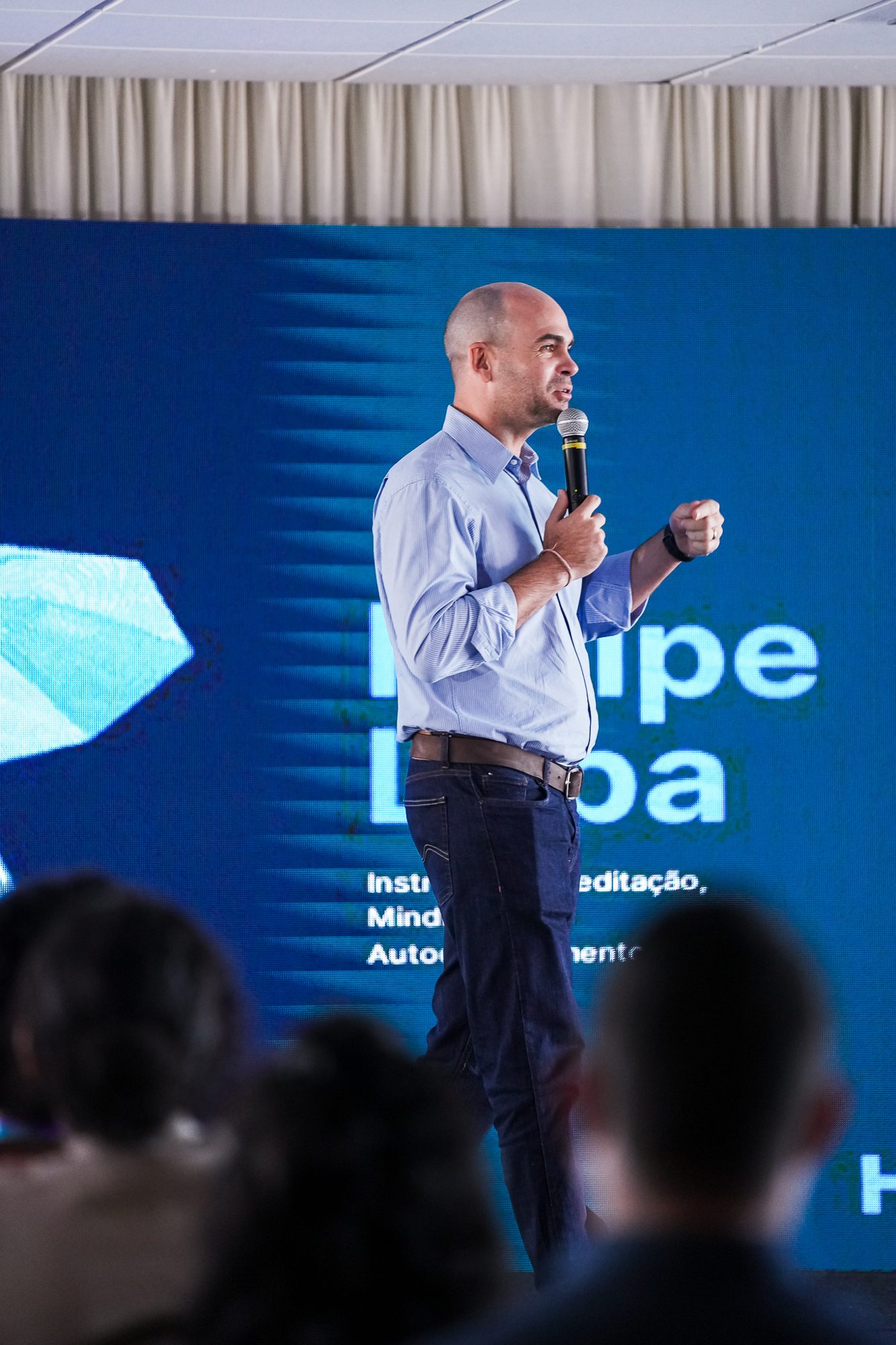 Felipe Lapa de pé no palco, falando ao microfone
